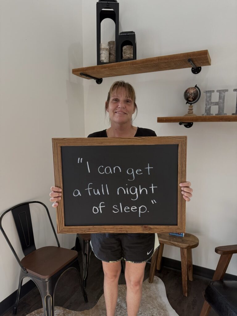 A Health From Within patient holding a chalkboard that reads: I can get a full night of sleep.